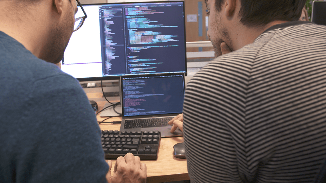 Two programmers examining code